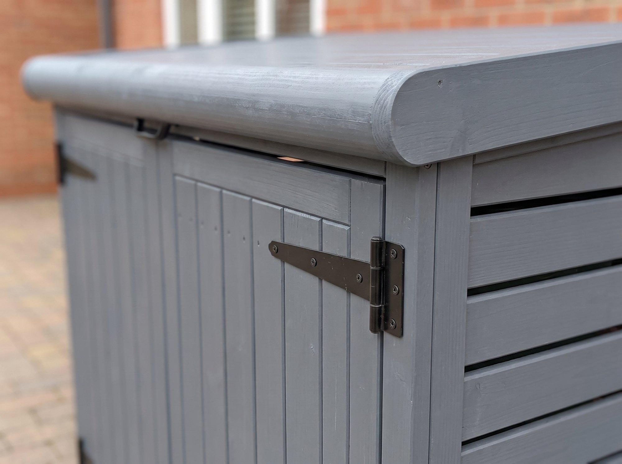 Close-up of the lifting lid, hinge and grey painted slats on the Radley double wheelie bin store
