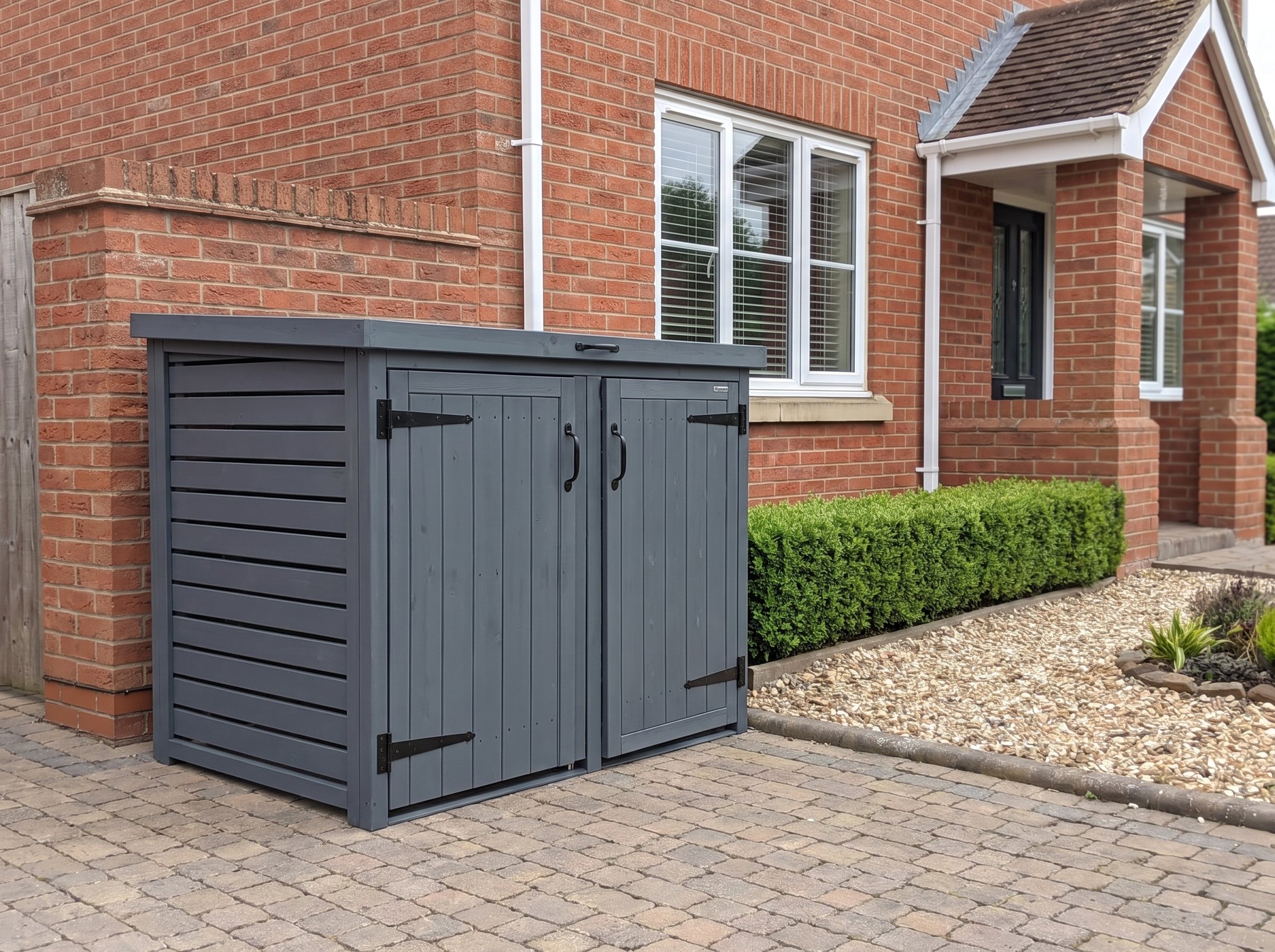 Radley double wheelie bin store on the driveway of a red brick house beside a clipped hedge